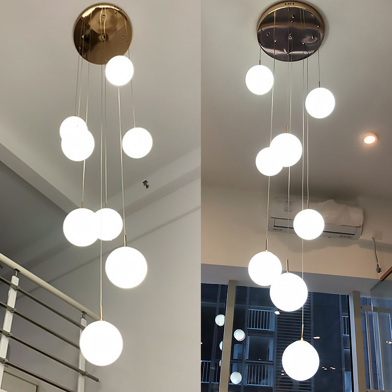 Plafonnier minimaliste doré à plusieurs suspensions avec bulles en verre crème et suspension d'escalier en verre blanc