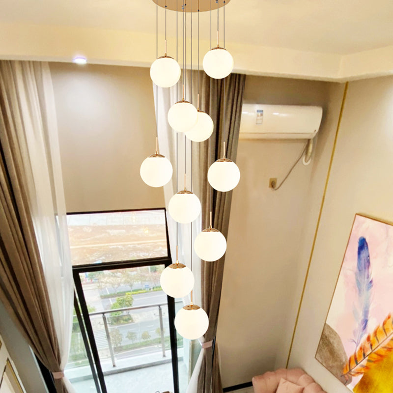 Plafonnier minimaliste doré à plusieurs suspensions avec bulles en verre crème et suspension d'escalier en verre blanc