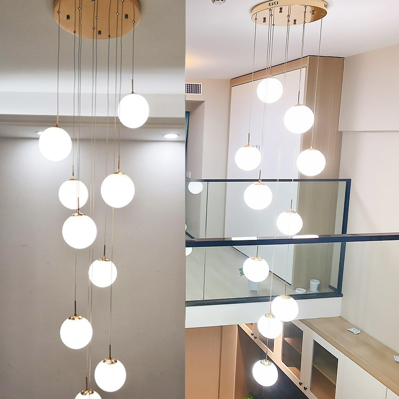 Plafonnier minimaliste doré à plusieurs suspensions avec bulles en verre crème et suspension d'escalier en verre blanc